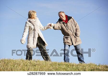 Stock Photo - Senior Man Pulling His Wife By The Hand. Fotosearch