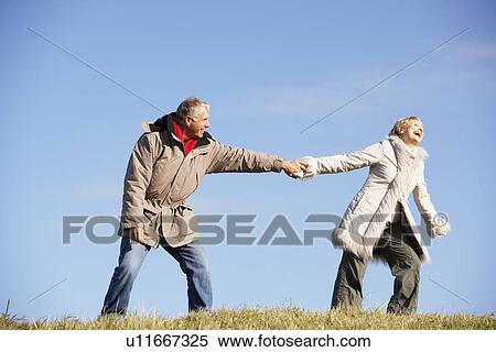 Stock Photography - Senior Man Pulling His Wife By The Hand. Fotosearch