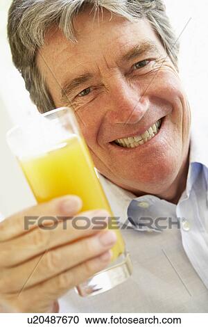 Senior Man Smiling At Camera And Drinking Orange Juice View Large Photo Image Stock Image - Senior Man Smiling At Camera And Drinking Orange Juice. Fotosearch
