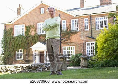 Stock Photograph - Senior Man Standing Outside House. Fotosearch