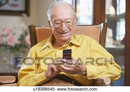 Stock Photography - Senior man text messaging. Fotosearch
