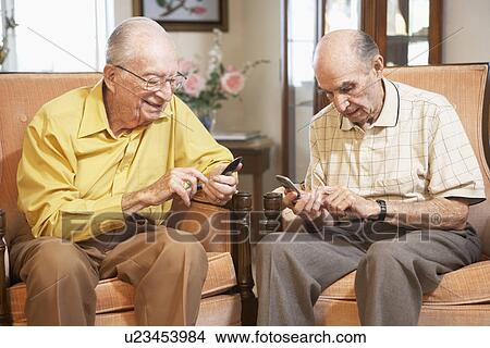Picture - Senior men text messaging. Fotosearch