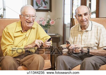 Stock Photography - Senior men text messaging. Fotosearch
