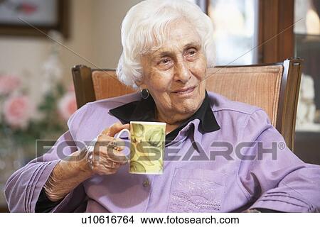 Picture - Senior woman drinking hot beverage. Fotosearch
