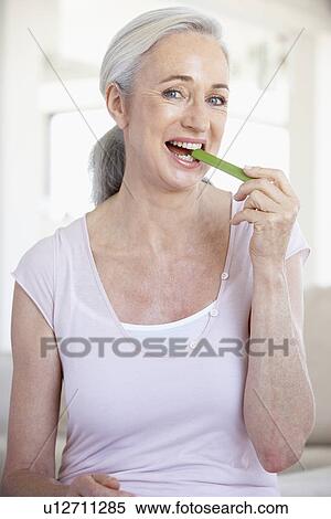 Stock Photography - Senior Woman Eating A Celery Stick. Fotosearch