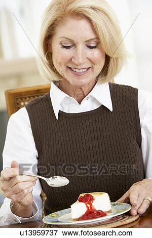 Stock Photo - Senior Woman Eating Cheesecake. Fotosearch