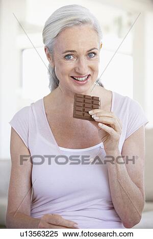 Stock Photography - Senior Woman Eating Chocolate. Fotosearch