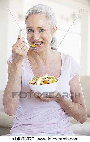 Stock Image - Senior Woman Eating Fresh Fruit Salad. Fotosearch