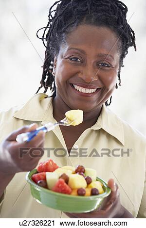 Stock Image - Senior Woman Eating Fresh Fruit Salad. Fotosearch