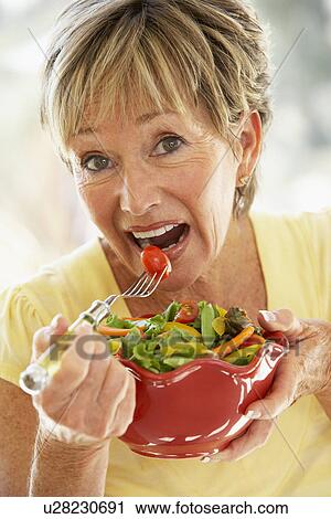 Stock Image - Senior Woman Eating Fresh Salad. Fotosearch