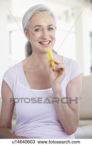 Stock Image - Senior Woman Eating Pineapple. Fotosearch