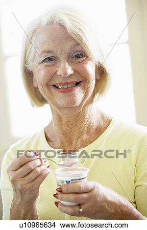 Picture - Senior Woman Eating Yogurt. Fotosearch
