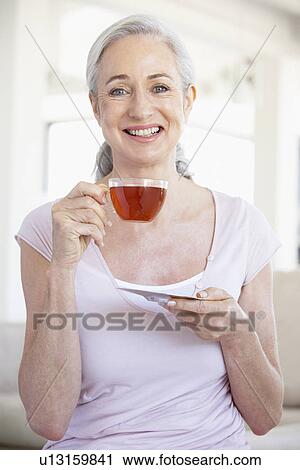 Senior Woman Holding Tea And Smiling At The Camera View Large Photo Image Stock Image - Senior Woman Holding Tea And Smiling At The Camera. Fotosearch