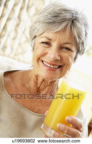 Senior Woman Smiling At Camera And Drinking Orange Juice View Large Photo Image Stock Image - Senior Woman Smiling At Camera And Drinking Orange Juice. Fotosearch