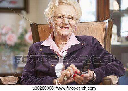 Stock Photo - Senior woman text messaging. Fotosearch