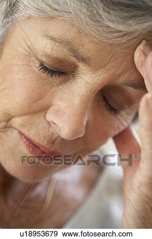 Stock Photo - Senior Woman With Head In Hands Looking Weary. Fotosearch