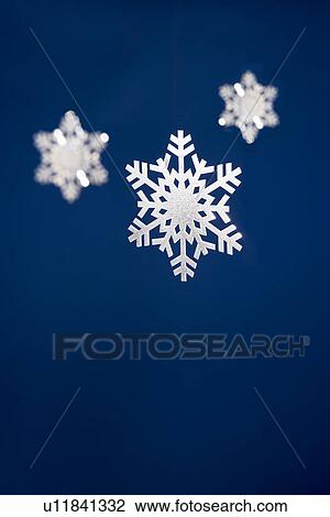 Stock Image - Snowflake Tree Decorations Against Blue Background. Fotosearch