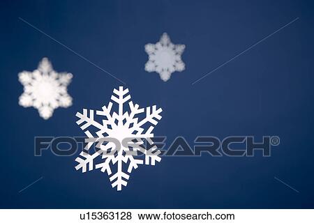 Stock Photo - Snowflake Tree Decorations Against Blue Background. Fotosearch