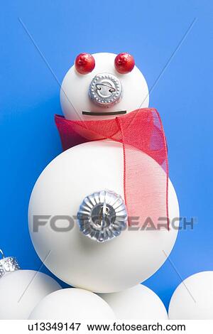Stock Photo - Snowman Made From Christmas Decorations Against Blue Background. Fotosearch