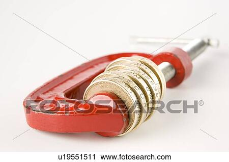 Stock Image - Stack Of Pound Coins In Red Clamp On White Background. Fotosearch