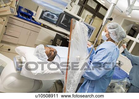 Stock Image - Surgeon Operating On Patient . Fotosearch