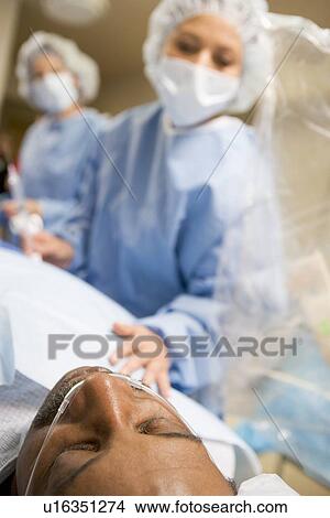 Picture - Surgeons Operating On Patient. Fotosearch