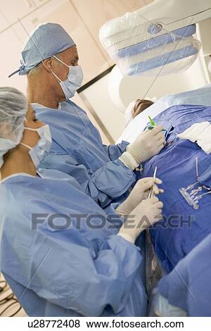Stock Photo - Surgeons Operating On Patient. Fotosearch