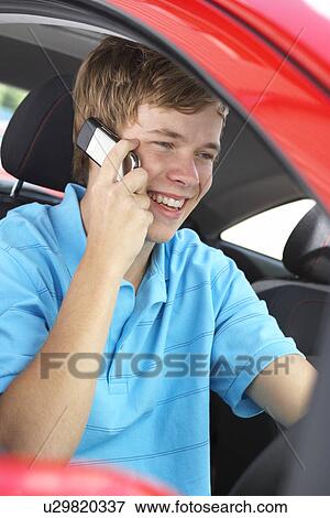 Stock Photo - Teenage Boy Sitting In Car, Talking On Cellphone. Fotosearch