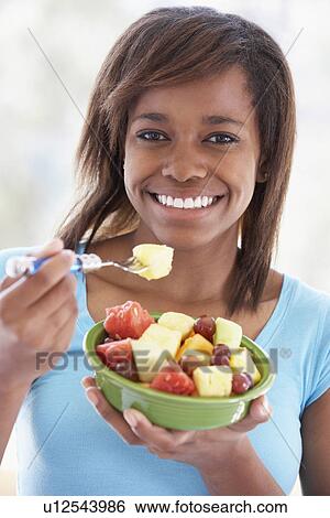 Stock Photograph - Teenage Girl Eating Fresh Fruit Salad. Fotosearch