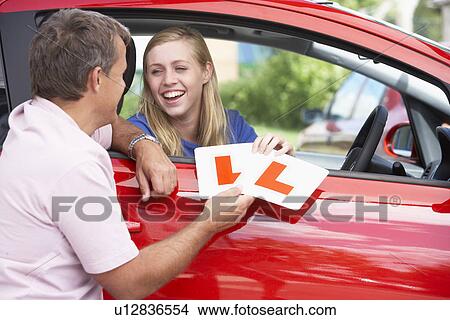 Picture - Teenage Girl Receiving Her Learner Plates. Fotosearch