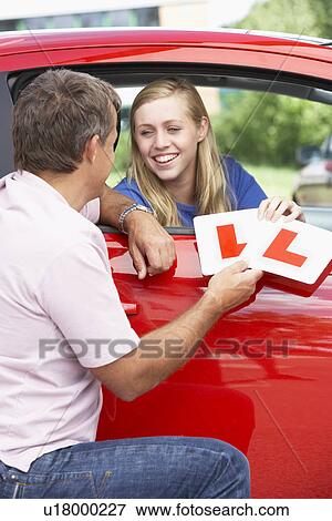 Stock Photo - Teenage Girl Receiving Her Learner Plates. Fotosearch