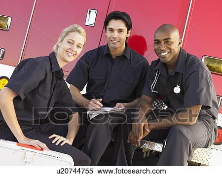 Three paramedics chatting and doing paperwork, sitting by their ambulance View Large Photo Image Stock Photography - Three paramedics chatting and doing paperwork, sitting by their ambulance. Fotosearch
