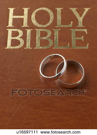 Stock Image - Wedding Rings Resting On A Holy Bible. Fotosearch