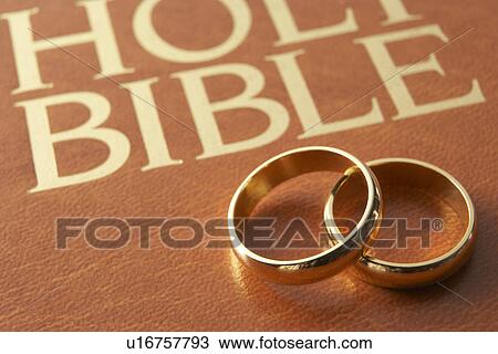 Stock Image - Wedding Rings Resting On A Holy Bible. Fotosearch