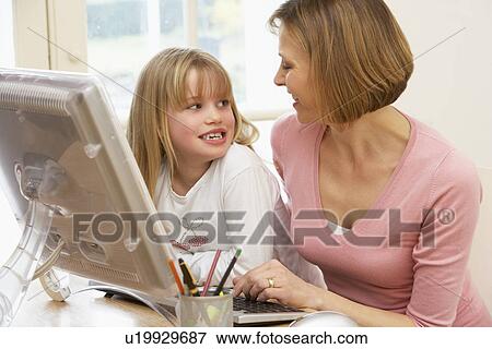 Stock Photo - Woman And Daughter Using Computer. Fotosearch