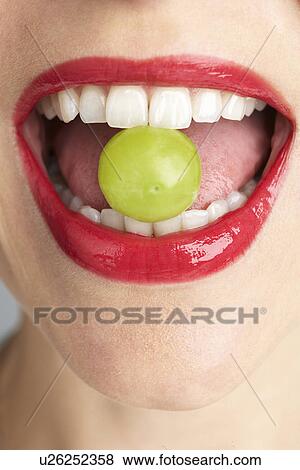 Stock Photo - Woman Biting Grape. Fotosearch