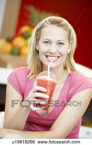 Stock Photograph - Woman Drinking A Berry Smoothie. Fotosearch