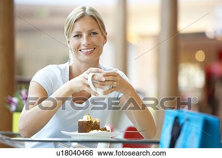 Stock Photograph - Woman Eating A Piece Of Cake At The Mall. Fotosearch
