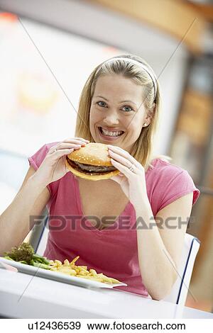 Stock Photo - Woman Eating Lunch At A Cafe. Fotosearch