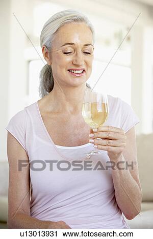 Stock Image - Woman Enjoying A Glass Of White Wine. Fotosearch