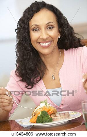 Stock Photograph - Woman Enjoying A Meal At Home. Fotosearch