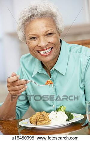 Stock Photography - Woman Enjoying A Meal At Home. Fotosearch