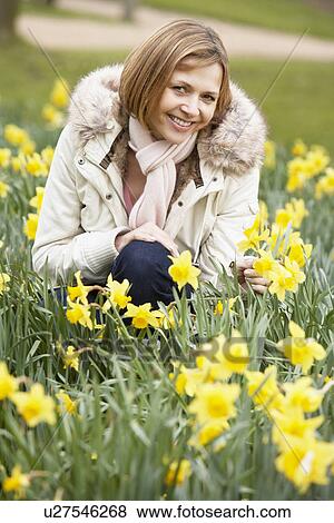 Stock Photo - Woman Kneeling In Daffodils. Fotosearch