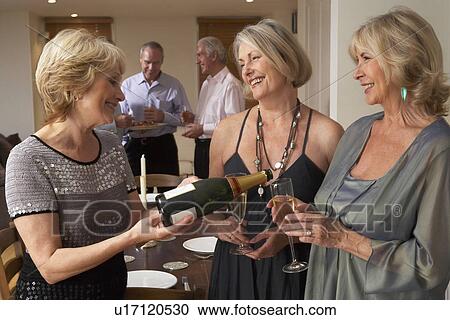 Woman Serving Champagne To Her Guests At A Dinner Party View Large Photo Image Stock Image - Woman Serving Champagne To Her Guests At A Dinner Party. Fotosearch