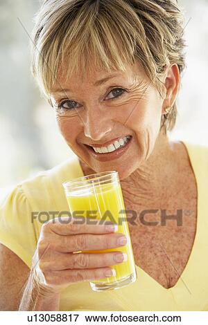 Woman Smiling At Camera Drinking Orange Juice View Large Photo Image Stock Photo - Woman Smiling At Camera Drinking Orange Juice. Fotosearch