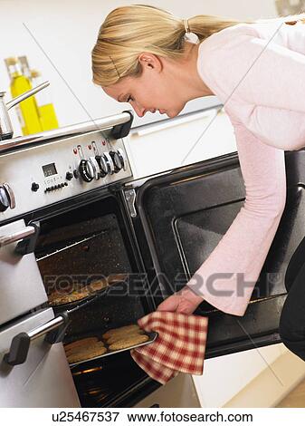 Woman Taking Cookies Out Of Oven View Large Photo Image Stock Photo - Woman Taking Cookies Out Of Oven. Fotosearch