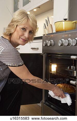 Woman Taking Food Out Of The Oven View Large Photo Image Stock Image - Woman Taking Food Out Of The Oven. Fotosearch
