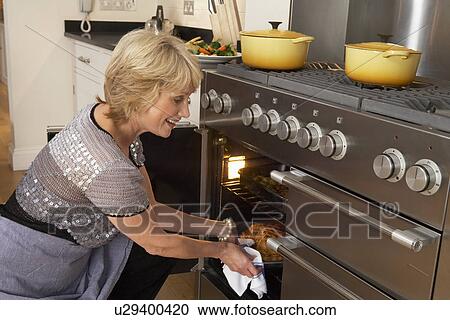 Woman Taking Food Out Of The Oven View Large Photo Image Stock Image - Woman Taking Food Out Of The Oven. Fotosearch