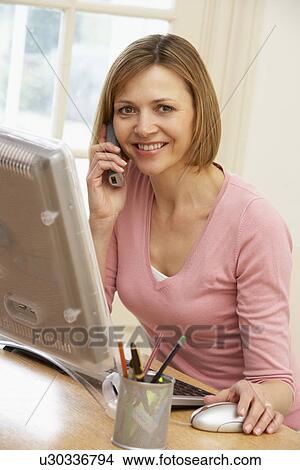 Woman Using Computer And Talking On Phone View Large Photo Image Picture - Woman Using Computer And Talking On Phone. Fotosearch