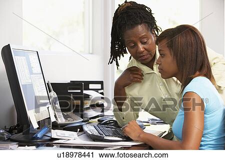 Stock Image - Woman Watching Her Daughter Use A Computer. Fotosearch